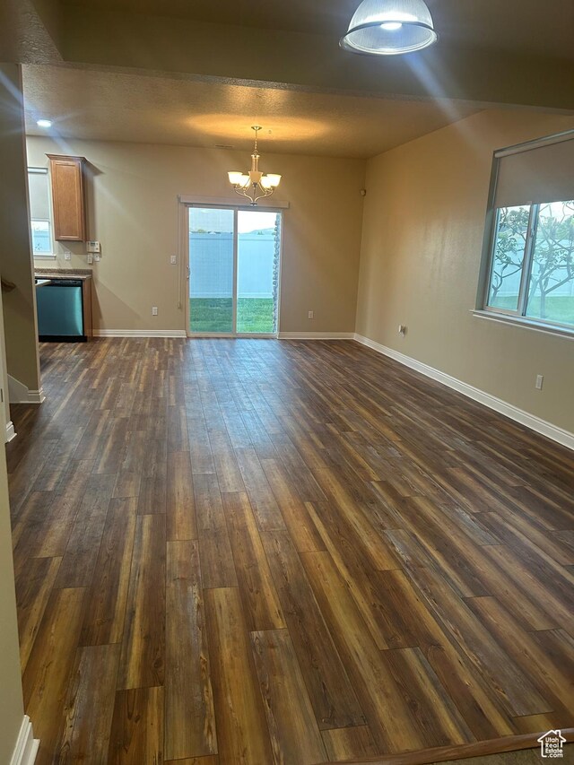 4673 W Greensand Dr, West Jordan, UT 84084 - unfurnished living room featuring a chandelier, dark wood finished floors, baseboards, and plenty of natural light