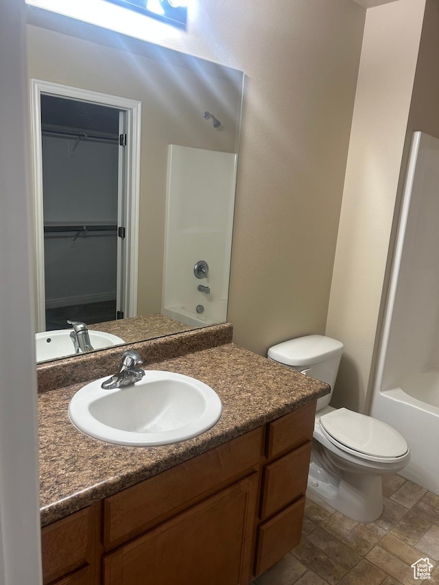 4673 W Greensand Dr, West Jordan, UT 84084 - bathroom with vanity, toilet, a spacious closet, bathing tub / shower combination, and stone finish flooring
