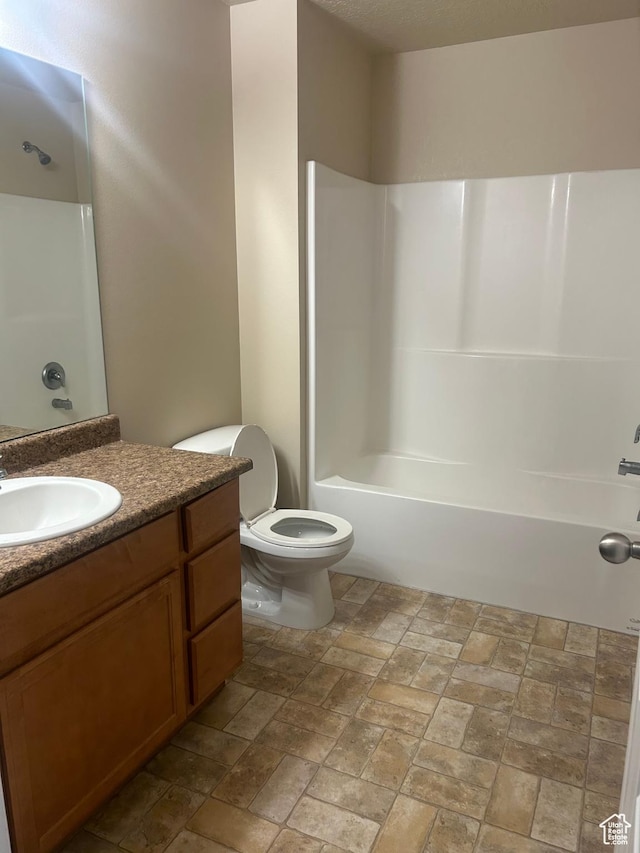 4673 W Greensand Dr, West Jordan, UT 84084 - bathroom featuring vanity, toilet,  shower combination, and stone finish floors