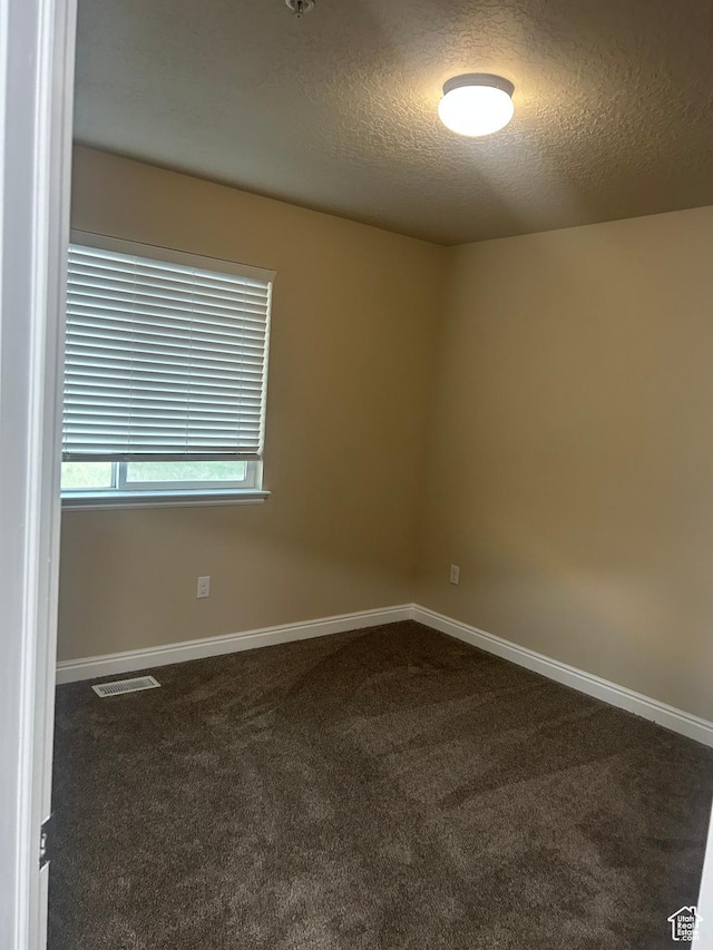 4673 W Greensand Dr, West Jordan, UT 84084 - empty room with dark colored carpet, a textured ceiling, and baseboards