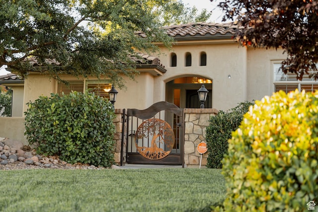 3288 W 2570 S, Hurricane, UT 84737 - view of front facade featuring stucco siding, a gate, a tiled roof, and a front yard