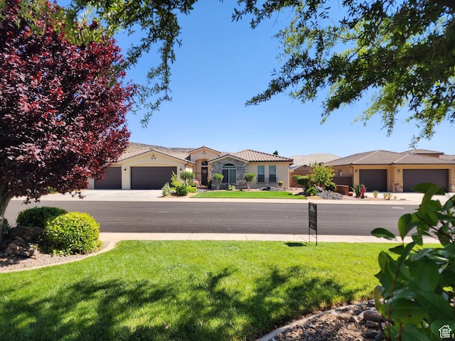 3288 W 2570 S, Hurricane, UT 84737 - view of front of property with a front yard, stucco siding, stone siding, and a tiled roof