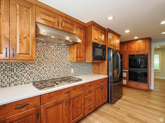 919 E 13800 S, Draper, UT 84020 - kitchen with black appliances, under cabinet range hood, brown cabinets, light countertops, and tasteful backsplash