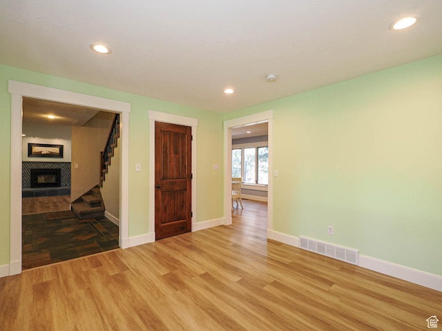 919 E 13800 S, Draper, UT 84020 - spare room featuring light wood-type flooring, a tiled fireplace, stairs, baseboards, and recessed lighting