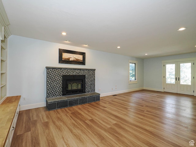 919 E 13800 S, Draper, UT 84020 - unfurnished living room featuring light wood-style floors, baseboards, recessed lighting, a fireplace, and french doors