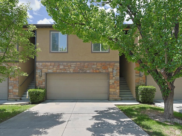 7198 S Milky Hollow Ln, West Jordan, UT 84084 - view of front of house featuring stairway, stone siding, a garage, and stucco siding