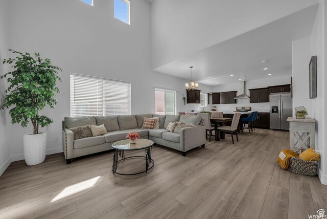 7217 N Hidden Steppe Bnd, Eagle Mountain, UT 84005 - living room with a chandelier, a towering ceiling, light wood-style flooring, recessed lighting, and baseboards