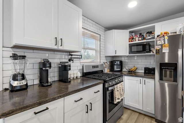 4206 S Whipoorwhil St W, West Valley City, UT 84120 - kitchen featuring stainless steel appliances, white cabinets, decorative backsplash, and dark stone counters