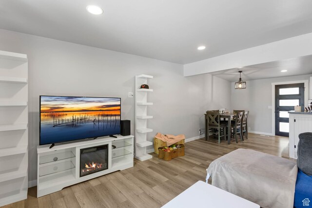 4206 S Whipoorwhil St W, West Valley City, UT 84120 - living area featuring wood finished floors, baseboards, recessed lighting, and a glass covered fireplace