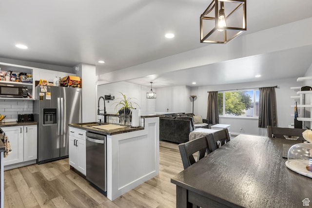 4206 S Whipoorwhil St W, West Valley City, UT 84120 - kitchen featuring stainless steel appliances, open floor plan, light wood finished floors, a chandelier, and white cabinetry