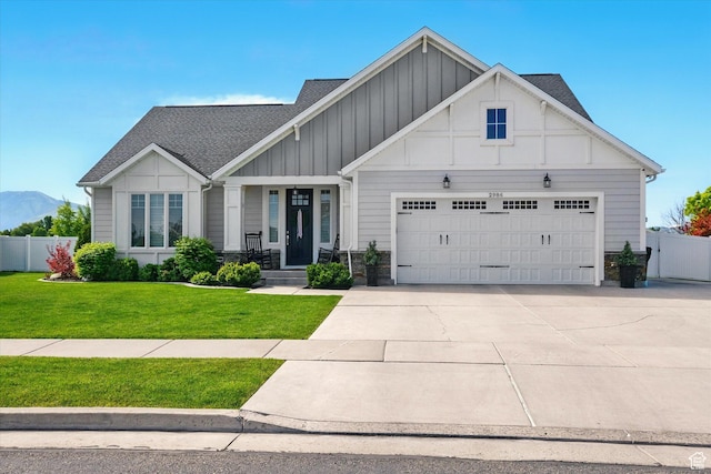 2986 S Stonebridge Dr W, Nibley, UT 84321 - craftsman-style home with board and batten siding, a garage, a shingled roof, driveway, and a mountain view