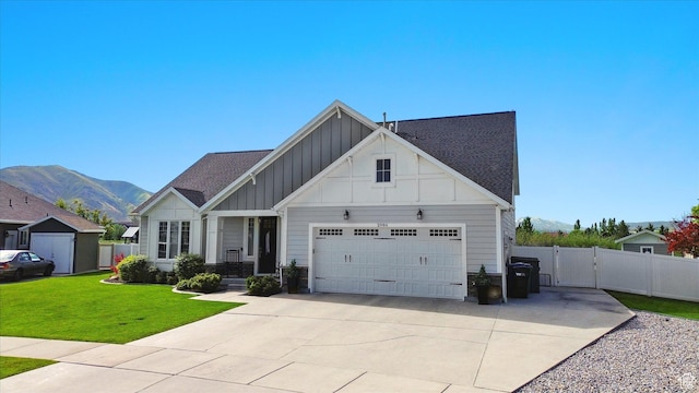 2986 S Stonebridge Dr W, Nibley, UT 84321 - view of front of house with board and batten siding, a garage, a mountain view, driveway, and a gate