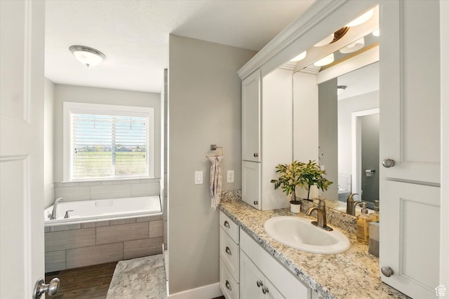 2986 S Stonebridge Dr W, Nibley, UT 84321 - bathroom featuring vanity, a garden tub, and wood finished floors