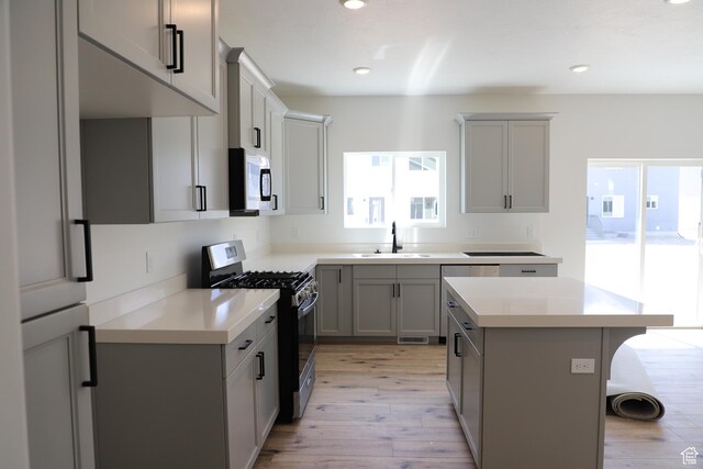 3711 N Janie St Unit 1015, Eagle Mountain, UT 84005 - kitchen with stainless steel range with gas cooktop, a sink, light wood-style flooring, gray cabinets, and recessed lighting