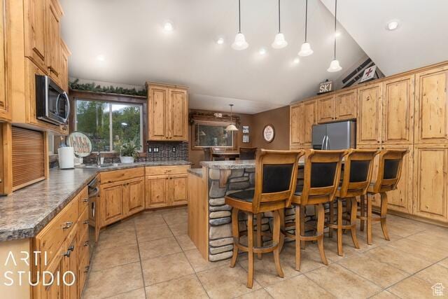 3575 N Foothill Ln, Eden, UT 84310 - kitchen with appliances with stainless steel finishes, tasteful backsplash, light tile patterned floors, a breakfast bar, and vaulted ceiling