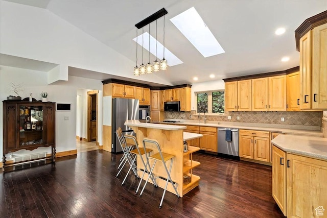 5548 E Emigration Canyon Rd E, Salt Lake City, UT 84108 - kitchen featuring appliances with stainless steel finishes, a skylight, light countertops, a kitchen bar, and light brown cabinetry