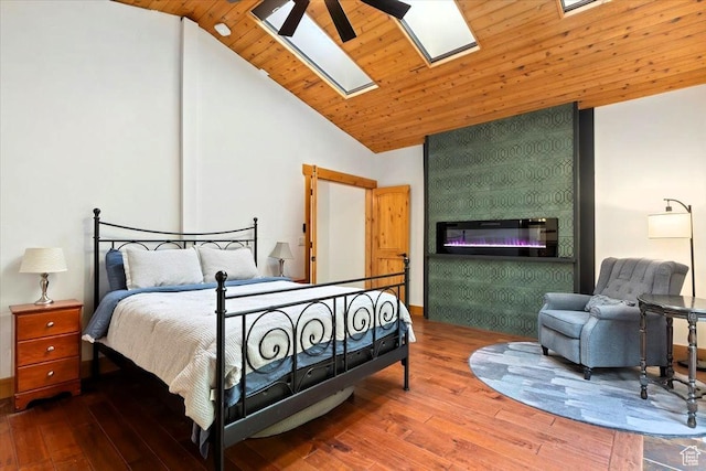 5548 E Emigration Canyon Rd E, Salt Lake City, UT 84108 - bedroom featuring hardwood / wood-style flooring, a skylight, high vaulted ceiling, and a large fireplace