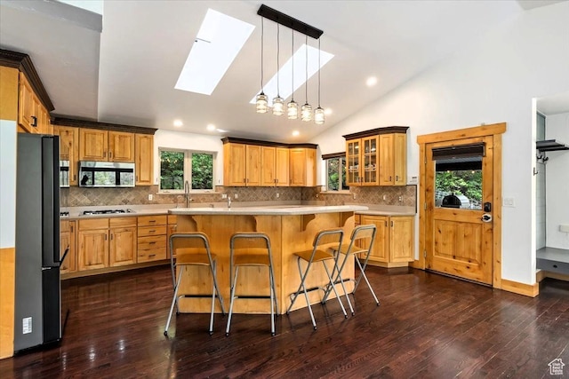 5548 E Emigration Canyon Rd E, Salt Lake City, UT 84108 - kitchen with stainless steel appliances, a skylight, light countertops, a kitchen breakfast bar, and vaulted ceiling