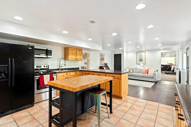 5548 E Emigration Canyon Rd E, Salt Lake City, UT 84108 - kitchen with black refrigerator with ice dispenser, stainless steel range with electric cooktop, white microwave, a sink, and a peninsula