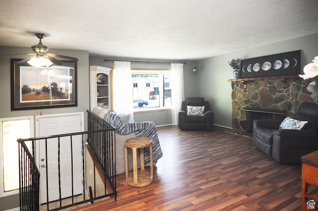 1185 W 725 N, Clearfield, UT 84015 - living area with wood finished floors, a textured ceiling, a ceiling fan, baseboards, and a stone fireplace
