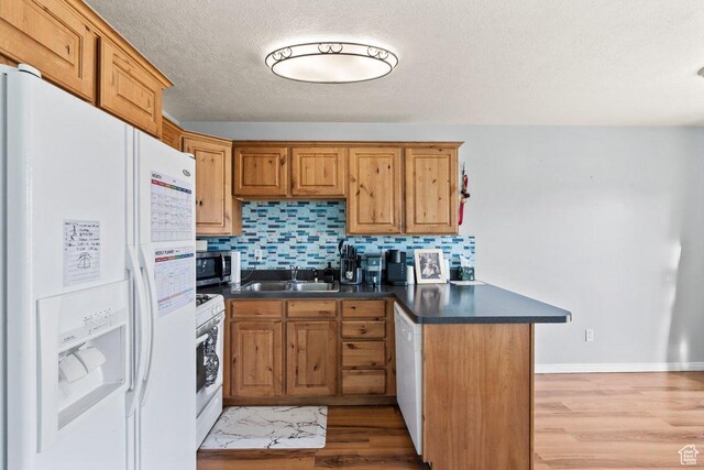 2856 W 3965 S Unit 78, West Haven, UT 84401 - kitchen featuring white appliances, a sink, dark countertops, a peninsula, and a textured ceiling