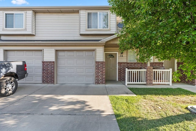 2856 W 3965 S Unit 78, West Haven, UT 84401 - view of front facade featuring brick siding, an attached garage, driveway, and a porch