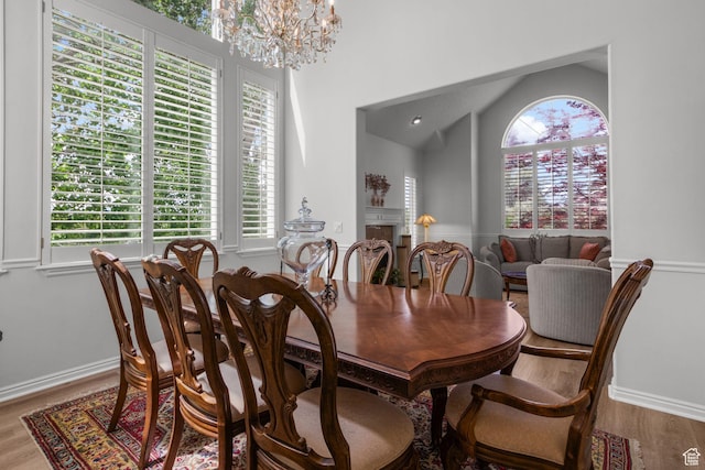 2016 E Graystone Ln S, Draper, UT 84020 - dining space featuring wood finished floors, a chandelier, a fireplace, vaulted ceiling, and baseboards