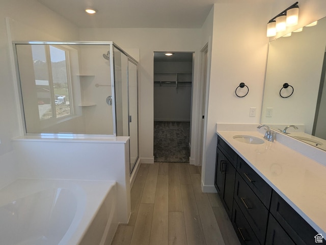 737 N Plainsman Dr Unit 108, Spanish Fork, UT 84660 - bathroom featuring a shower stall, wood finished floors, a garden tub, vanity, and recessed lighting