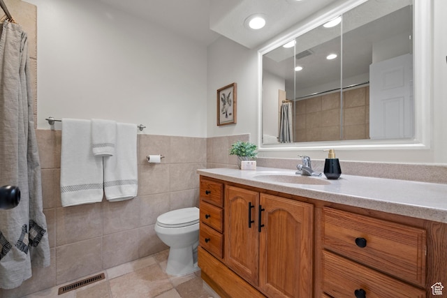 2592 S 50 W, Bountiful, UT 84010 - bathroom with vanity, tile walls, tiled shower, tile patterned floors, and toilet