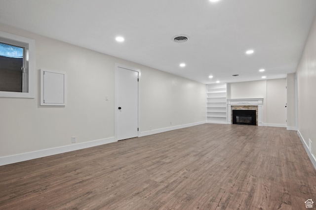 2592 S 50 W, Bountiful, UT 84010 - unfurnished living room with wood finished floors, built in shelves, recessed lighting, baseboards, and a stone fireplace