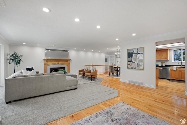 2592 S 50 W, Bountiful, UT 84010 - living area with crown molding, recessed lighting, a tiled fireplace, light wood-type flooring, and baseboards