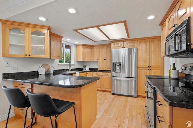 2592 S 50 W, Bountiful, UT 84010 - kitchen with appliances with stainless steel finishes, a peninsula, light wood-style flooring, a breakfast bar, and glass insert cabinets