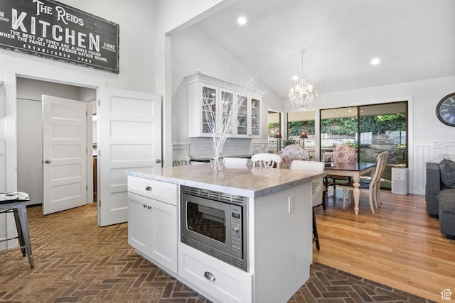 1900 N 1400 E, Provo, UT 84604 - kitchen featuring stainless steel microwave, white cabinetry, a chandelier, brick floors, and a kitchen island