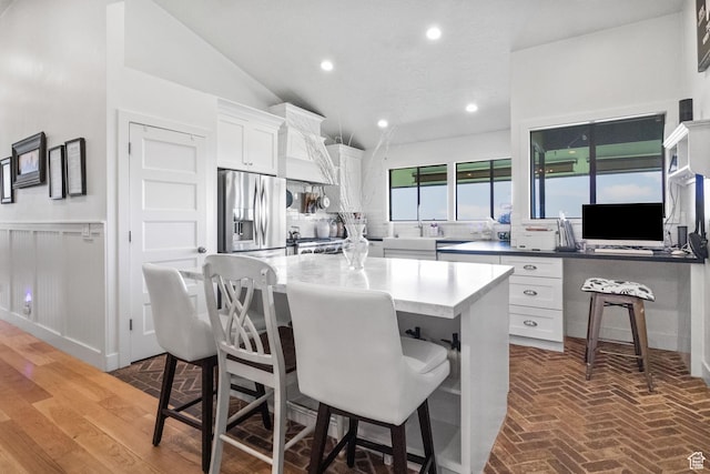 1900 N 1400 E, Provo, UT 84604 - kitchen featuring stainless steel refrigerator with ice dispenser, white cabinets, a breakfast bar area, a kitchen island, and lofted ceiling