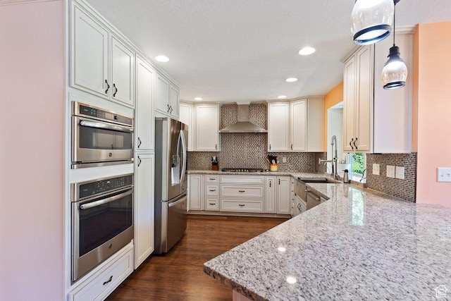2149 E 3325 N, Layton, UT 84040 - kitchen with appliances with stainless steel finishes, wall chimney exhaust hood, light stone countertops, a sink, and backsplash