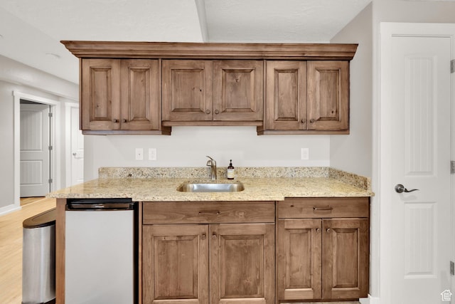7215 S Aerie Hill Dr W, West Jordan, UT 84081 - kitchen with a sink, light stone countertops, light wood-style floors, and brown cabinets