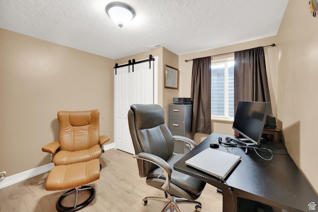 7215 S Aerie Hill Dr W, West Jordan, UT 84081 - office area featuring wood finished floors, a textured ceiling, baseboards, and a barn door
