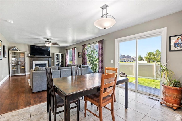 2007 N 850 E, North Ogden, UT 84414 - dining room featuring ceiling fan, a fireplace, baseboards, a textured ceiling, and tile patterned flooring