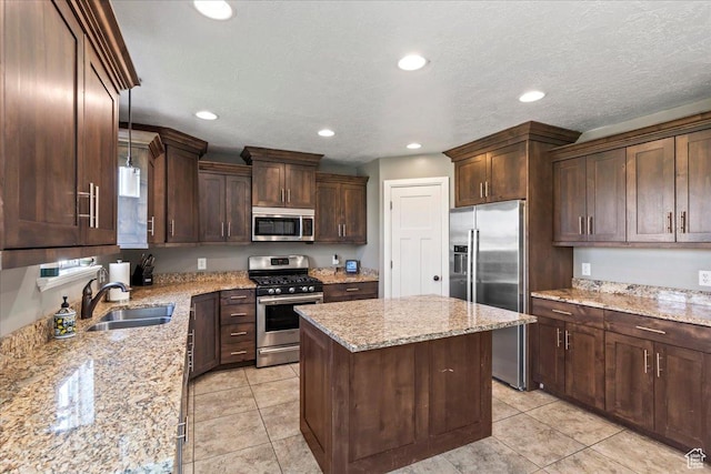 2007 N 850 E, North Ogden, UT 84414 - kitchen featuring appliances with stainless steel finishes, a sink, a kitchen island, recessed lighting, and dark brown cabinets