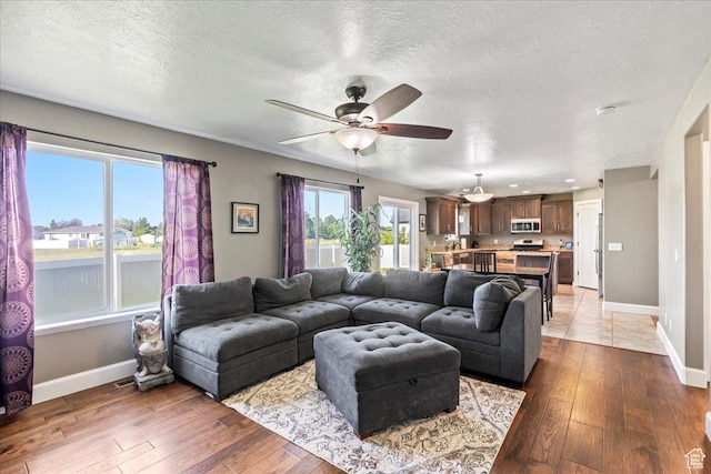 2007 N 850 E, North Ogden, UT 84414 - living area with baseboards, a textured ceiling, hardwood / wood-style floors, and a ceiling fan