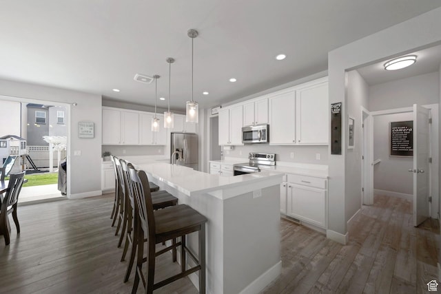 6178 W Sugarcane Dr, South Jordan, UT 84009 - kitchen with stainless steel appliances, a center island with sink, dark wood-type flooring, white cabinetry, and recessed lighting