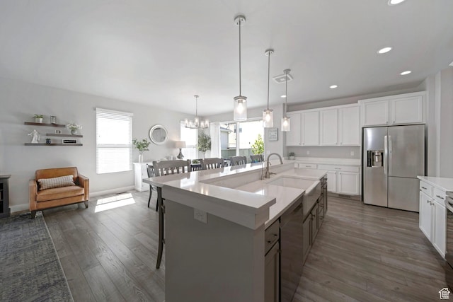 6178 W Sugarcane Dr, South Jordan, UT 84009 - kitchen with stainless steel appliances, a sink, a kitchen bar, dark wood-style floors, and light countertops