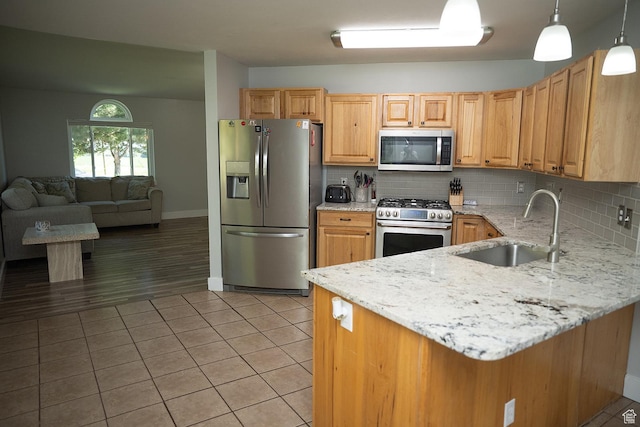 170 W 500 N, Wellsville, UT 84339 - kitchen featuring appliances with stainless steel finishes, light stone counters, tasteful backsplash, light tile patterned floors, and a peninsula