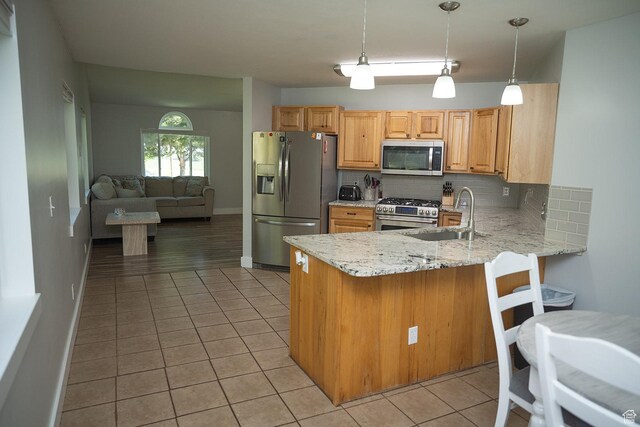 170 W 500 N, Wellsville, UT 84339 - kitchen with appliances with stainless steel finishes, decorative backsplash, light tile patterned flooring, light stone countertops, and a peninsula
