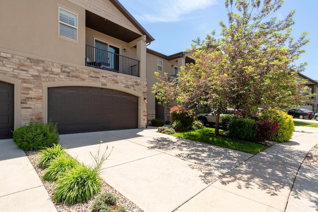 688 N 255 W, Centerville, UT 84014 - view of front of property with stone siding, stucco siding, an attached garage, concrete driveway, and a balcony