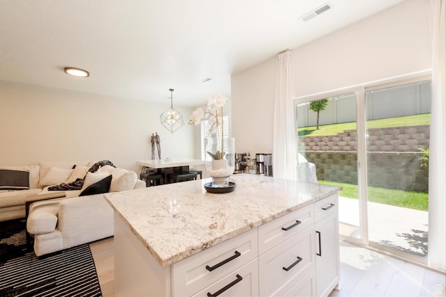 688 N 255 W, Centerville, UT 84014 - kitchen featuring light stone counters, white cabinets, a kitchen island, open floor plan, and recessed lighting