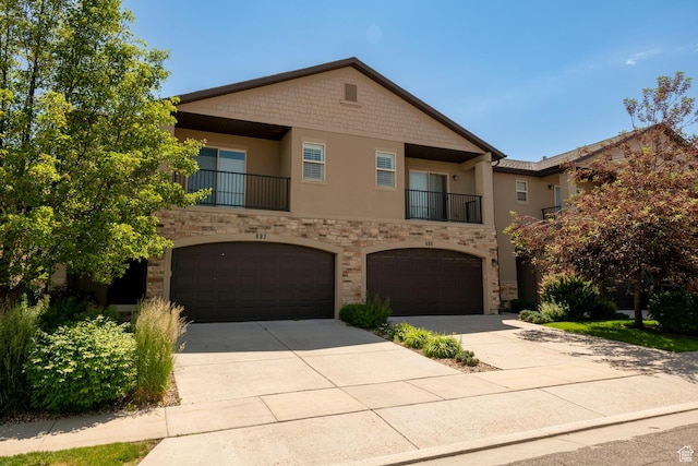 688 N 255 W, Centerville, UT 84014 - townhome / multi-family property with stucco siding, stone siding, a garage, driveway, and a balcony