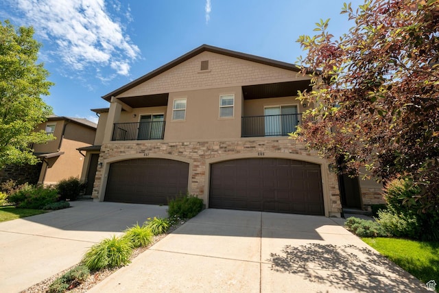 688 N 255 W, Centerville, UT 84014 - view of front facade featuring concrete driveway, an attached garage, stucco siding, stone siding, and a balcony