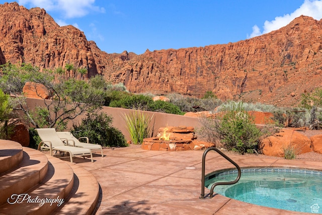 1936 N Uwan Dr, Ivins, UT 84738 - view of swimming pool featuring a fire pit, a patio, a mountain view, and a fenced backyard