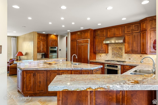 1936 N Uwan Dr, Ivins, UT 84738 - kitchen featuring appliances with stainless steel finishes, under cabinet range hood, a sink, a warming drawer, and recessed lighting